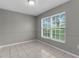 A bright, tiled empty room with a large window overlooking a green space at 5112 Odin St, Spring Hill, FL 34608