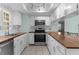 Bright kitchen featuring white cabinetry, butcher block countertops, and modern stainless steel appliances at 5112 Odin St, Spring Hill, FL 34608