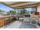 Covered outdoor kitchen and bar area with a built-in grill, bar seating, and an open backyard at 5112 Odin St, Spring Hill, FL 34608
