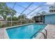 Refreshing screened-in pool with tile trim and brick-paver decking, offering a relaxing backyard retreat at 5112 Odin St, Spring Hill, FL 34608