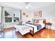 Bright bedroom boasts wood floors, ceiling fan, stylish decor, and window providing ample natural light at 5730 Imperial Ky, Tampa, FL 33615