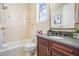 Well-appointed bathroom with dark wood cabinets, granite countertop, and shower-tub combo at 650 Geneva Pl, Tampa, FL 33606