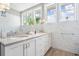 Elegant bathroom with dual sinks, white marble subway tile, and views from several windows at 650 Geneva Pl, Tampa, FL 33606