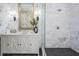 Modern bathroom with a marble shower, vanity, mirror, and chic wallpaper at 650 Geneva Pl, Tampa, FL 33606