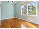 Light-filled bedroom featuring hardwood floors and two windows offering views of lush greenery at 650 Geneva Pl, Tampa, FL 33606