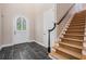 Inviting foyer with arched front door, decorative glass and stone tile flooring, leading to carpeted stairs at 650 Geneva Pl, Tampa, FL 33606