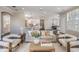Open-concept living room with gray couch, cream chairs, and adjacent kitchen island at 650 Geneva Pl, Tampa, FL 33606