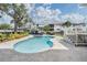 Inviting kidney shaped pool and spillover spa surrounded by travertine tile and landscaping at 650 Geneva Pl, Tampa, FL 33606