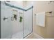 Modern shower with white tile, blue accents, glass enclosure, and wall niches for toiletries at 650 Geneva Pl, Tampa, FL 33606