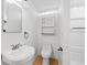 This bathroom has a white sink and toilet with white walls and wooden floor at 716 35Th W St, Bradenton, FL 34205