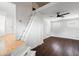 A bright room with wood floors, a ceiling fan, and stairs to an upper loft area at 716 35Th W St, Bradenton, FL 34205