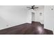 An empty room features dark wood floors, a ceiling fan, and stairs to an upper level at 716 35Th W St, Bradenton, FL 34205