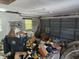 Cluttered garage interior with a garage door, shelves, and discarded items at 8109 Franklin Rd, Plant City, FL 33565