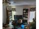 Untidy living room with old TV, overflowing bookshelves, and outdated decorations at 8109 Franklin Rd, Plant City, FL 33565