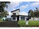 Modern two-story home showcasing a minimalist aesthetic with clean lines and a fresh, inviting black and white exterior at 8274 Rose Ter, Seminole, FL 33777