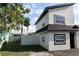 Stylish two-story home featuring neutral stucco, black trim, lush green lawn, complemented by mature tropical foliage at 8274 Rose Ter, Seminole, FL 33777