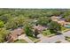 An aerial view of a neighborhood with mature trees, well-kept lawns, and homes with inviting curb appeal at 945 Winding Oaks Dr, Palm Harbor, FL 34683