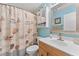 Bathroom featuring a shower with a decorative curtain, oak vanity, and blue wall color at 945 Winding Oaks Dr, Palm Harbor, FL 34683