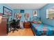 A blue bedroom is furnished with a desk, bed, and decorated with colorful items at 945 Winding Oaks Dr, Palm Harbor, FL 34683