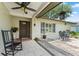 Inviting front porch with decorative plants, seating, and tile flooring at 945 Winding Oaks Dr, Palm Harbor, FL 34683