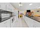Bright kitchen features white cabinets, dark countertops, tiled backsplash, and a spacious center island at 945 Winding Oaks Dr, Palm Harbor, FL 34683