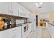 Bright eat-in kitchen features white cabinets, tiled backsplash, and modern appliances, offering style and functionality at 945 Winding Oaks Dr, Palm Harbor, FL 34683
