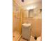 Tiled bathroom featuring a shower with gold trim and neutral colored sink with medicine cabinet at 9510 Mark Twain Ln, Port Richey, FL 34668