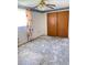 An empty bedroom featuring wood closet doors and a ceiling fan at 9510 Mark Twain Ln, Port Richey, FL 34668