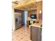 Functional kitchen with stainless steel fridge, tile backsplash, and patterned tile flooring at 9510 Mark Twain Ln, Port Richey, FL 34668