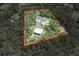 Expansive property featuring a home, pool, outbuildings, and surrounded by lush greenery at 23268 Family Ln, Brooksville, FL 34602