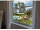 View of private backyard with pool, covered area, and lush, tropical landscaping at 23268 Family Ln, Brooksville, FL 34602
