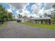 Exterior view of the back of the house showing the extensive covered parking, covered porch, pool, and screened in room at 23268 Family Ln, Brooksville, FL 34602