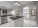 Kitchen island with granite countertop, white cabinets, and an open view to the living area at 23268 Family Ln, Brooksville, FL 34602