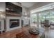 Bright living room with fireplace, flatscreen TV, rustic wood mantle and view to the sun room at 23268 Family Ln, Brooksville, FL 34602
