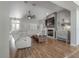 Open living room with wood floors, fireplace, TV, ceiling fan, and comfortable seating at 23268 Family Ln, Brooksville, FL 34602