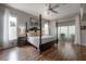 Spacious main bedroom featuring hardwood floors, a four-poster bed, and large windows at 23268 Family Ln, Brooksville, FL 34602