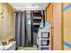 Enclosed bathroom with toilet, shelving and shower featuring a gray curtain at 10044 Oana St, New Port Richey, FL 34654