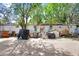 This exterior shot displays the yard of a vintage mobile home, under trees and shadows at 10044 Oana St, New Port Richey, FL 34654