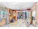 View of living room, kitchen and wall coverings in disrepair at 10044 Oana St, New Port Richey, FL 34654