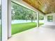 Covered porch and backyard featuring a well-maintained lawn, and a white fence at 1015 W Charter St, Tampa, FL 33602