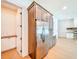 Stainless steel refrigerator and adjacent pantry in a home with light wood flooring and stone fireplace at 1015 W Charter St, Tampa, FL 33602
