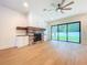 Bright living room with a stone fireplace, wooden floors, and a sliding door to backyard at 1015 W Charter St, Tampa, FL 33602