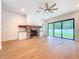 Living room featuring a stone fireplace, ceiling fan, and sliding glass doors to the yard at 1015 W Charter St, Tampa, FL 33602