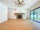 Open concept living room with stone fireplace, ceiling fan, and access to backyard at 1015 W Charter St, Tampa, FL 33602
