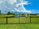 Spacious backyard with black metal fence, offering beautiful views of the pond and surrounding landscape at 10621 Scenic Hollow Dr, Riverview, FL 33578