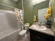 Well-lit bathroom featuring a shower-tub combination and a decorative shower curtain at 10621 Scenic Hollow Dr, Riverview, FL 33578