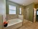 Clean, bright bathroom with a large tub and walk-in shower, providing a comfortable and luxurious experience at 10621 Scenic Hollow Dr, Riverview, FL 33578