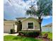 Inviting single-story home featuring a manicured lawn, tasteful landscaping, and mature palm tree at 10621 Scenic Hollow Dr, Riverview, FL 33578