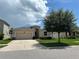 Charming single-Gathering home with a manicured lawn, attached two-car garage, and a shade tree at 10621 Scenic Hollow Dr, Riverview, FL 33578
