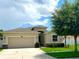 Charming single-Gathering home with a two-car garage, well-manicured lawn, and beautiful landscaping at 10621 Scenic Hollow Dr, Riverview, FL 33578